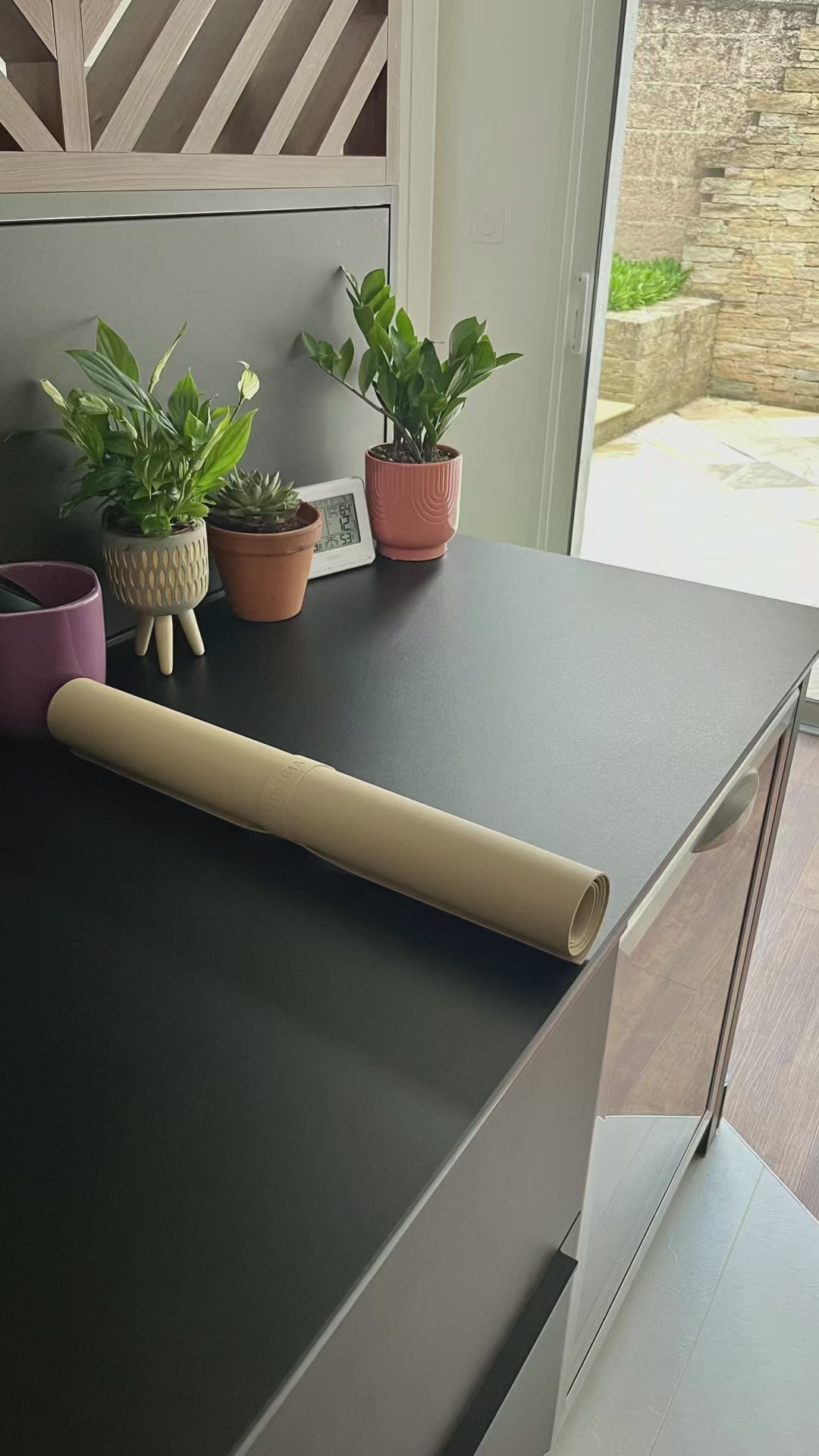 Vidéo qui illustre un tapis qui se déroule pour ensuite procéder à un rempotage d'une plante grasse.